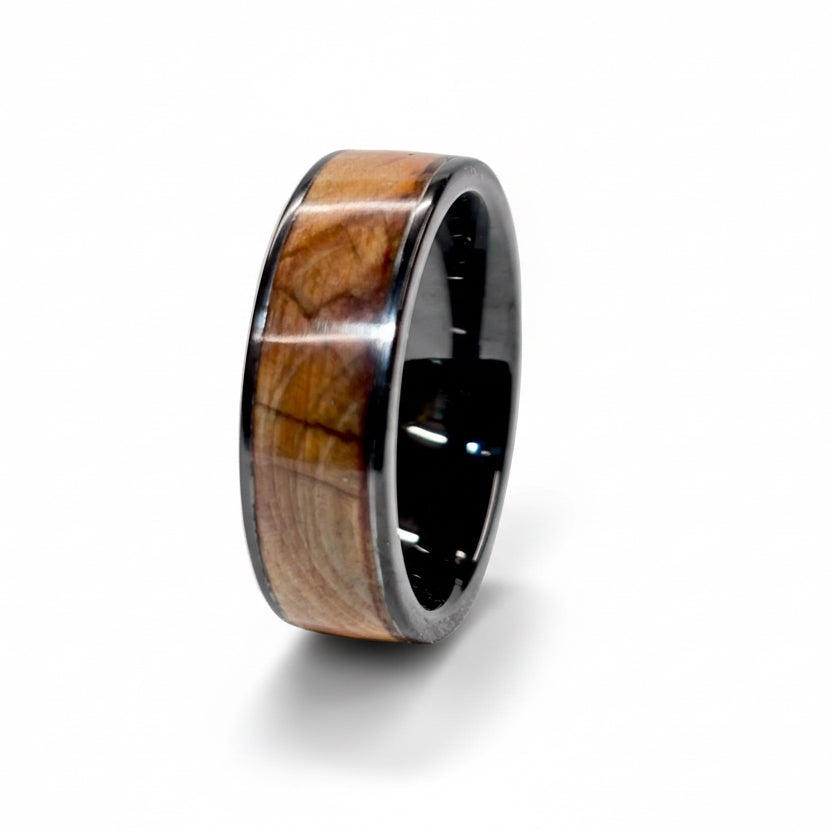 Wooden ring with black metal band on a white background